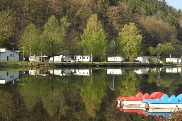 Camping Clausensee Blick vom See auf den Wohnwagen und Zeltstellplatz und Mobilheime vom Campingplatz 768x512