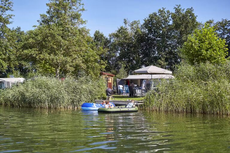 Camping TerSpegelt Boot fahrende Camper auf dem See am Campingplatz 768x512
