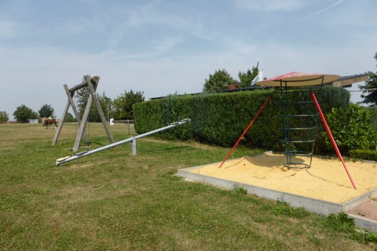 Komfort Campingplatz Panoramablick Kinderspielplatz mit Schaukel und Klettergeruest auf dem Campingplatz 768x512