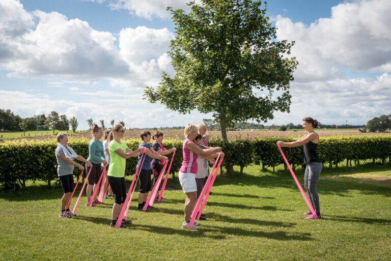 Rosenfelder Strand Ostsee Camping Gaeste beim Stretchingunterricht auf dem Campingplatzgelaende 768x513