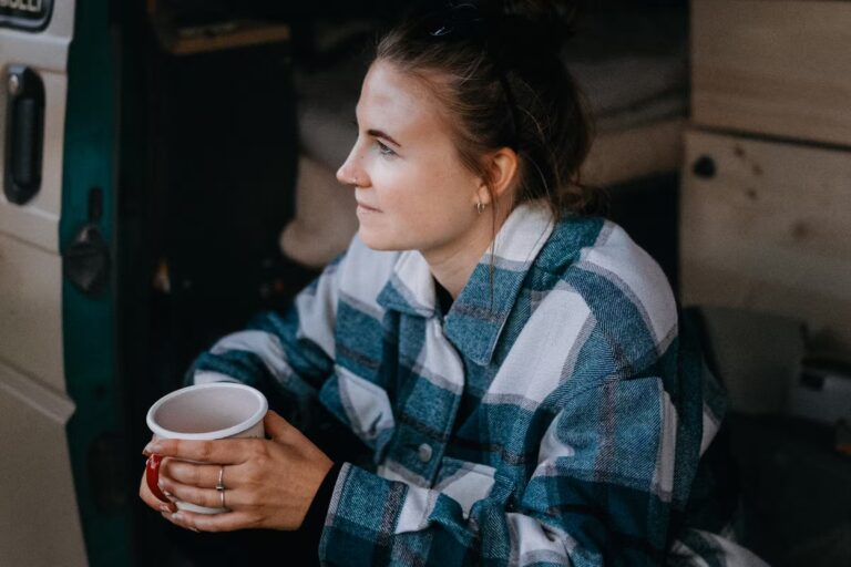 Wildwood Camping Harz Camping Waldweben Camperin sitzt in ihrem Van und geniesst einen Kaffee 7f02d5cf 49b0 487e ac45 8dde49d1e893 768x512