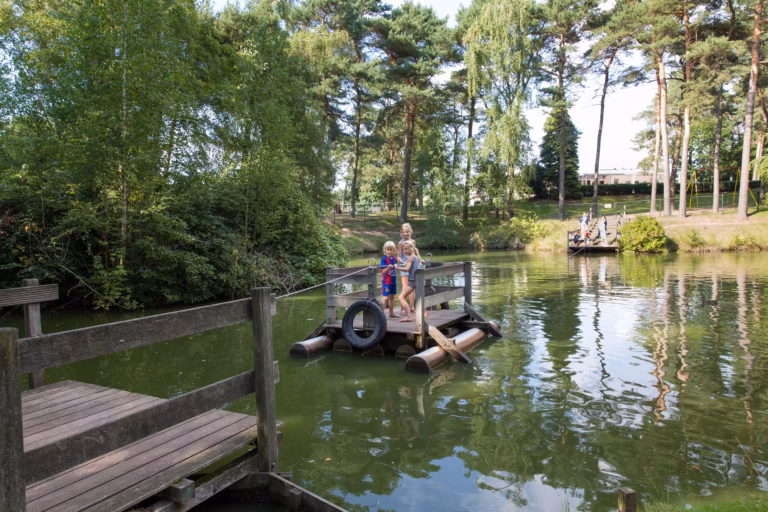 Ardoer Camping De Heldense Bossen Familie spielt beim Wasserspielplatz 768x512