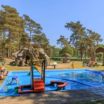 Ardoer Camping De Heldense Bossen Kinderbecken mit Baum Wasserrutsche auf dem Campingplatz 150x150