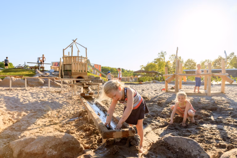 Vakantiepark Ackersate Familie spielt im Sand beim Sandspielplatz 768x512