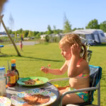 Vakantiepark Ackersate Familien essen vor dem Wohnmobil im Schatten der Markise 150x150