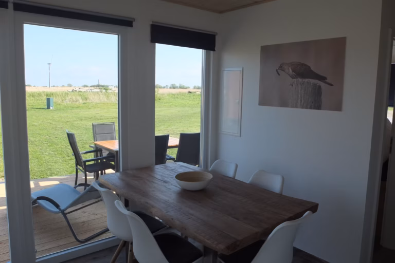 Campingplatz Flueggerteich Esstisch im Mobilheim mit Blick auf die Veranda auf dem Campingplatz im Gruenen 768x512