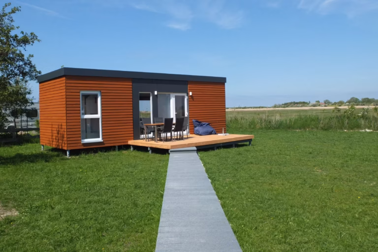 Campingplatz Flueggerteich Mobilheim vom Campingplatz mit Sitzsack und Esstisch auf der Veranda 768x512